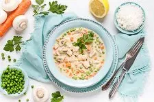 Fertiges Hühnerfrikassee mit Reis angerichtet auf einem Teller