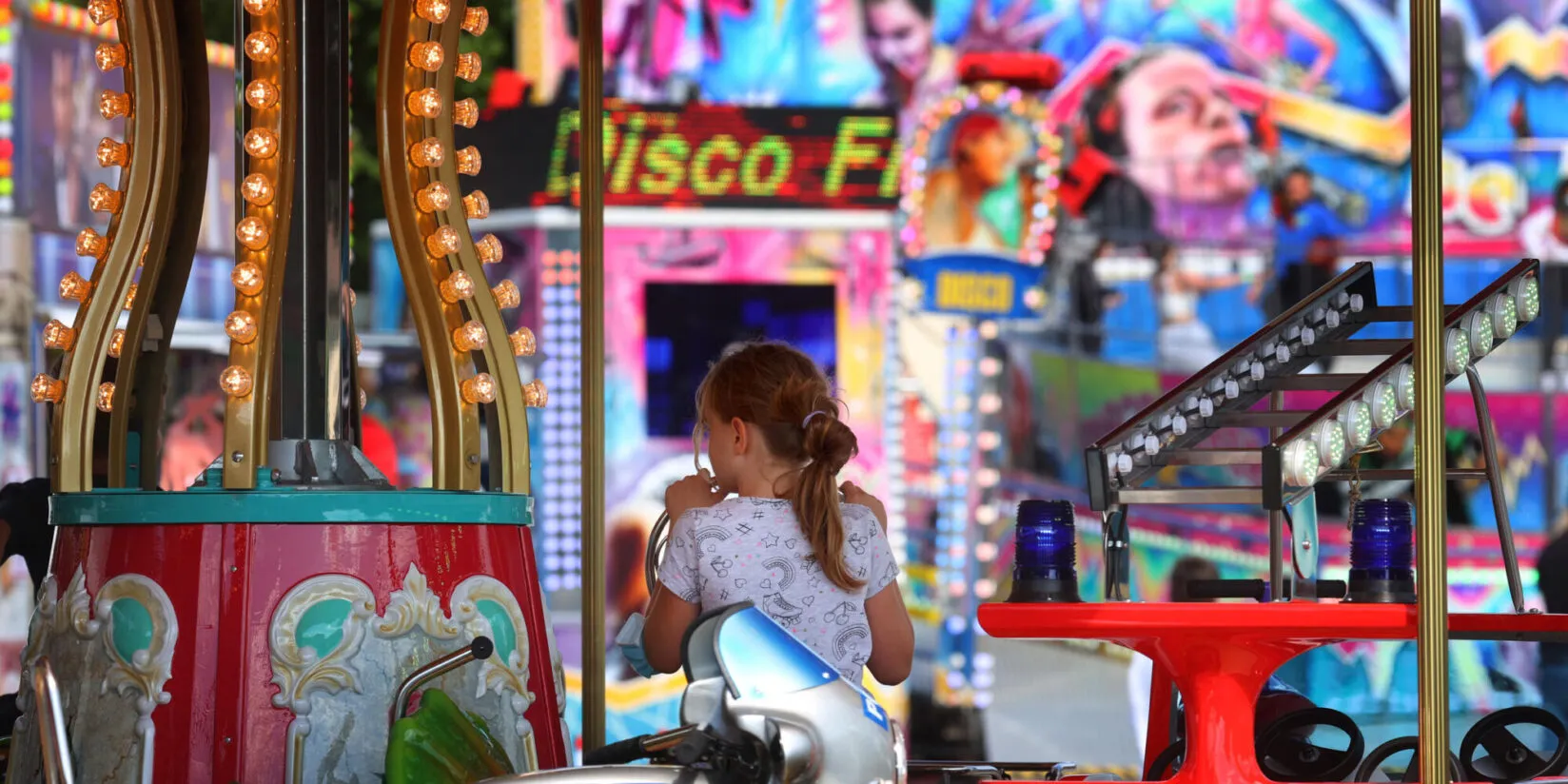 Festlich beleuchteter Weihnachtsmarkt in der Abenddämmerung mit Menschenmengen und Ständen