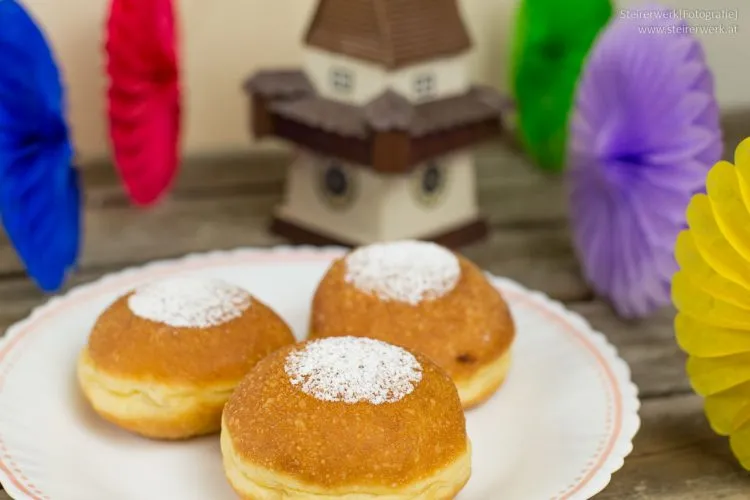Festlich dekorierte Faschingskrapfen mit einem Hauch Puderzucker, bereit für die Faschingszeit, symbolisieren deutsche Süßspeisenkultur.