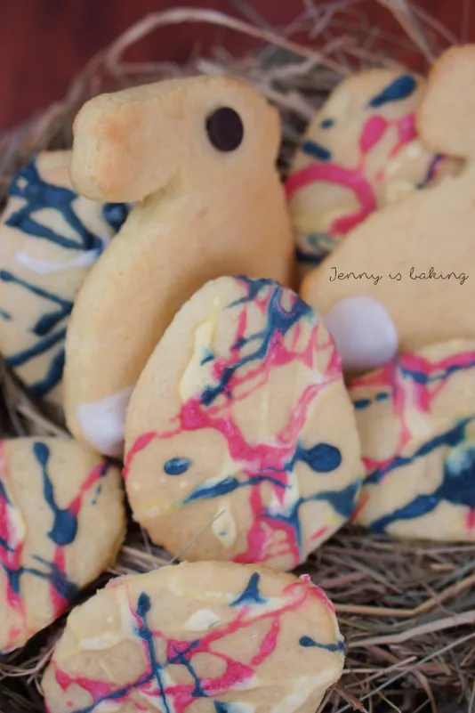 Festlich dekorierte Schmandplätzchen in Hasen- und Eierform, perfekt für die Osterzeit.