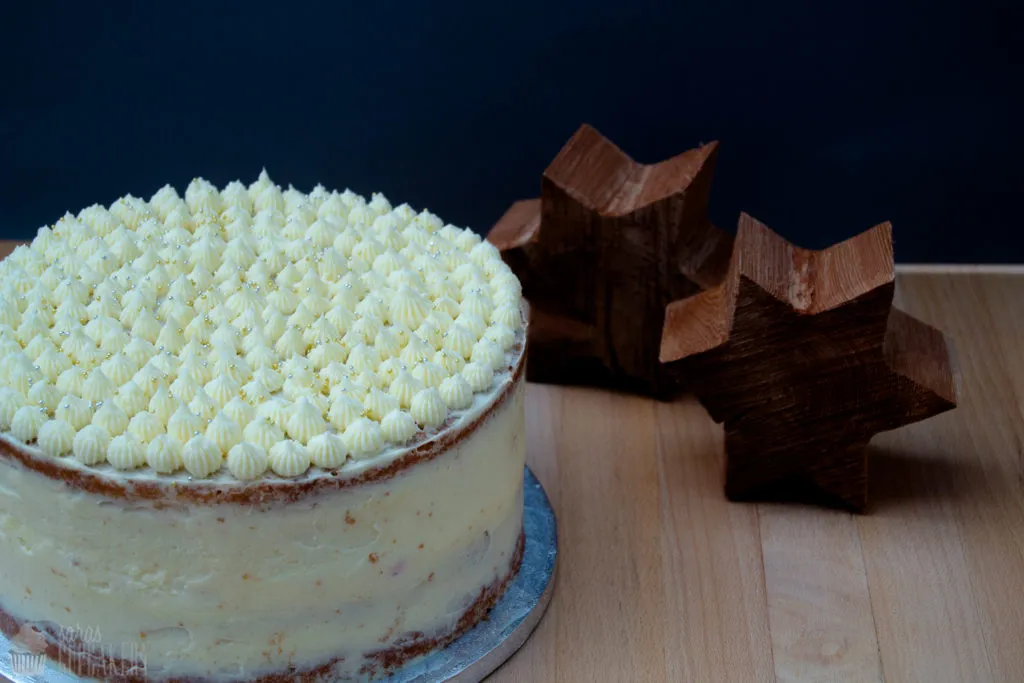 Festlich dekorierter Naked Cake mit Kirsch-Vanille-Füllung und Vanille-Frosting für einen besonderen Geburtstag.