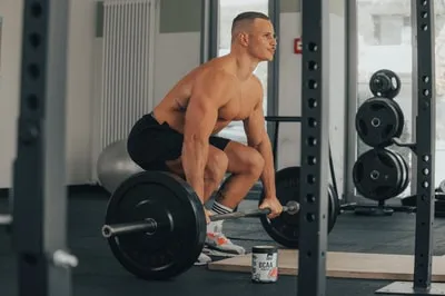 Fitness-Sportler Leon nutzt schwarze Zughilfen für verbesserten Griff und höhere Leistung beim Krafttraining.