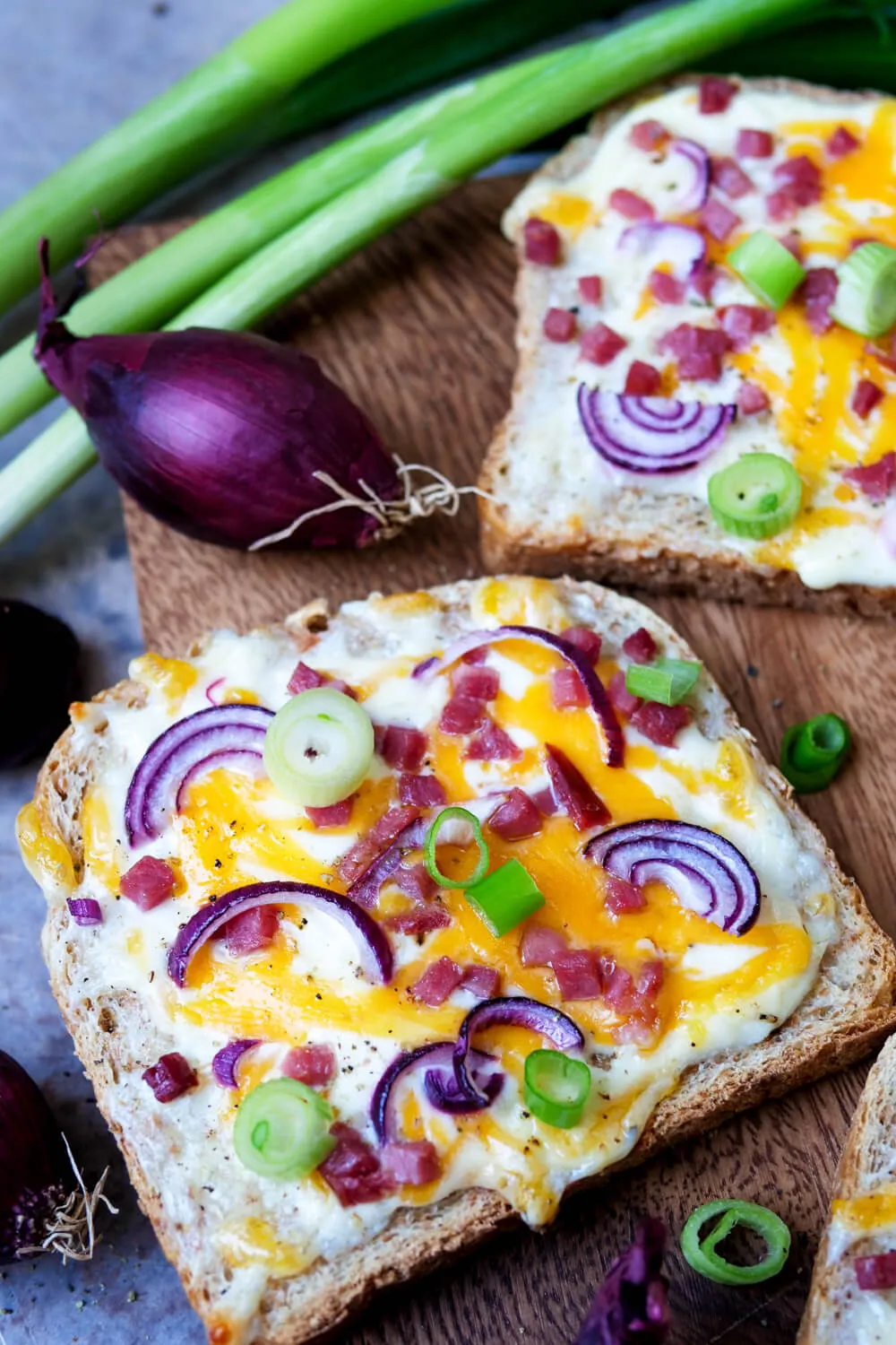 Flammkuchen-Toast mit Speck, Zwiebeln und Schmand nach Elsässer Art. Alternative Text: Traditioneller Flammkuchen-Toast belegt mit Speck, Zwiebeln und Schmand, nach Elsässer Art, ein schnelles und deftiges Mittagessen.