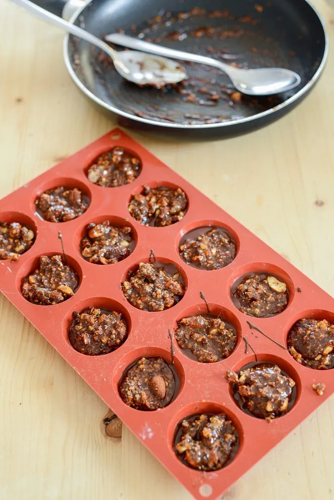 Florentiner Masse wird in kleine Backförmchen verteilt, bevor sie abkühlt und fest wird.