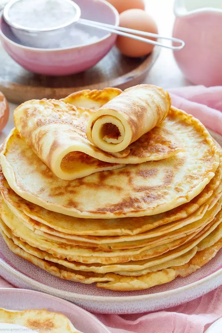 Fluffige, goldbraun gebackene Pfannkuchen auf einem Teller, fertig zum Servieren.
