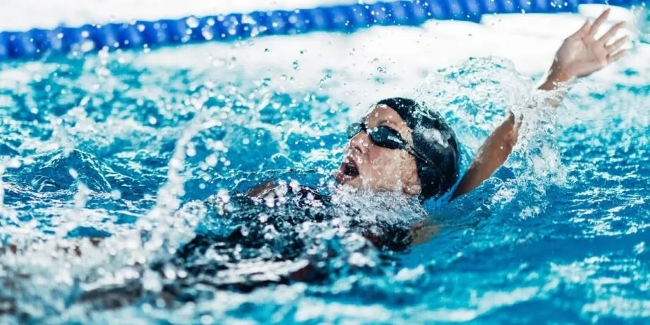 Frau beim Rückenschwimmen im Schwimmbecken
