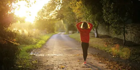 Frau genießt Nordic Walking im Sonnenuntergang für hohe Kalorienverbrennung.