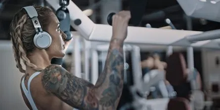 Frau macht Krafttraining an Geräten im Fitnessstudio für Frauen