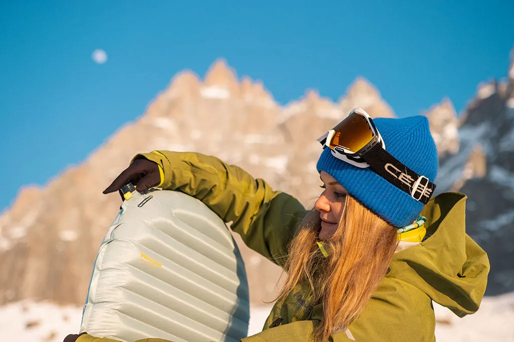 Frau plant Reise am Laptop, Tasse Kaffee und Karte auf dem Tisch