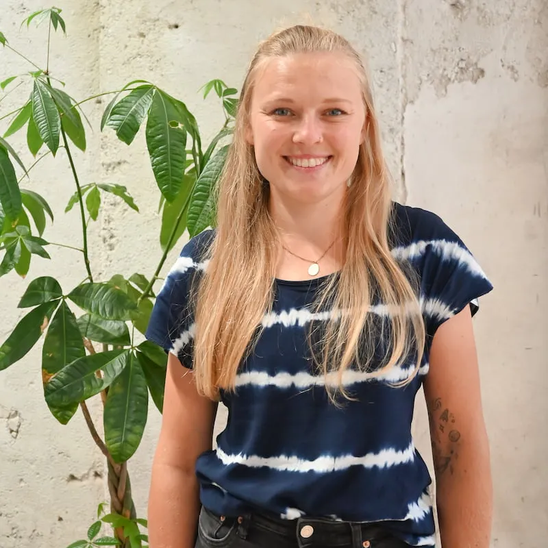 Frau vor grüner Pflanze