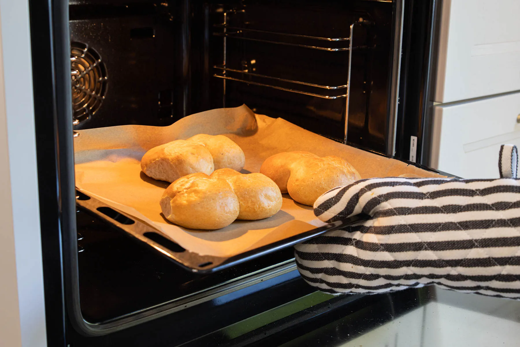 Frisch aufgebackene Brötchen auf einem Backblech im Ofen