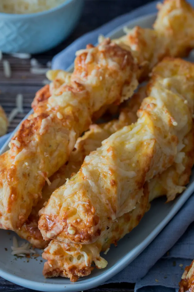 Frisch gebackene goldbraune Käsestangen, perfekt als herzhaftes Gebäck für die Brotdose.