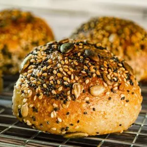 Frisch gebackene, goldbraune Körnerbrötchen auf einem Gitterrost