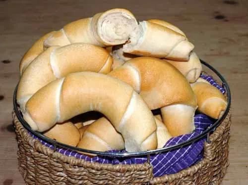 Frisch gebackene Hörnchen Brötchen mit goldbrauner Kruste auf einem Teller, bereit zum Genießen