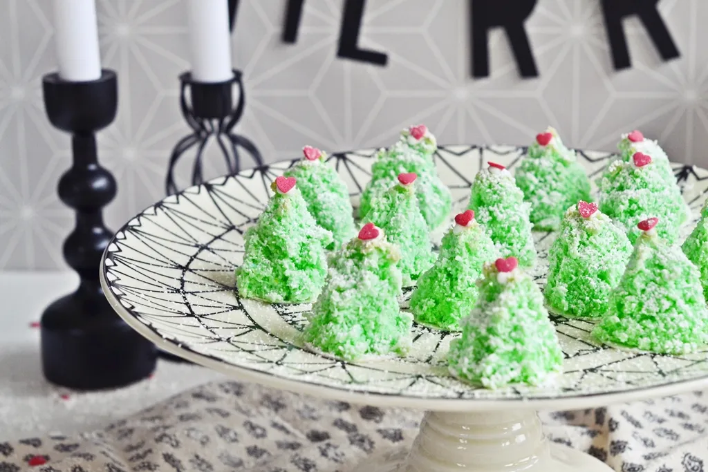 Frisch gebackene Kokosmakronen-Tannenbäume auf Backpapier, bereit zum Abkühlen