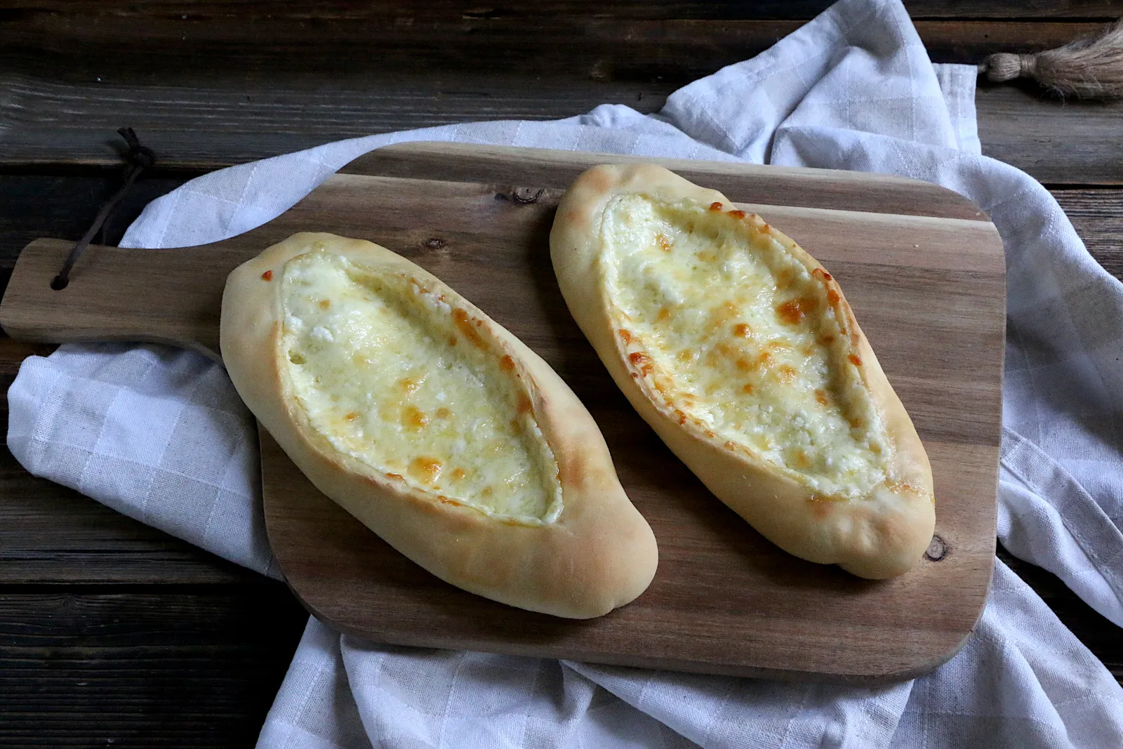 Frisch gebackene Pide mit Käsefüllung auf einem Holzbrett