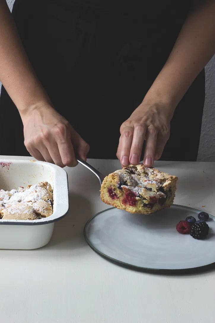 Frisch gebackener Beerenkuchen vom Blech mit saftigen Heidelbeeren und Himbeeren, ein beliebtes deutsches Sommergebäck.