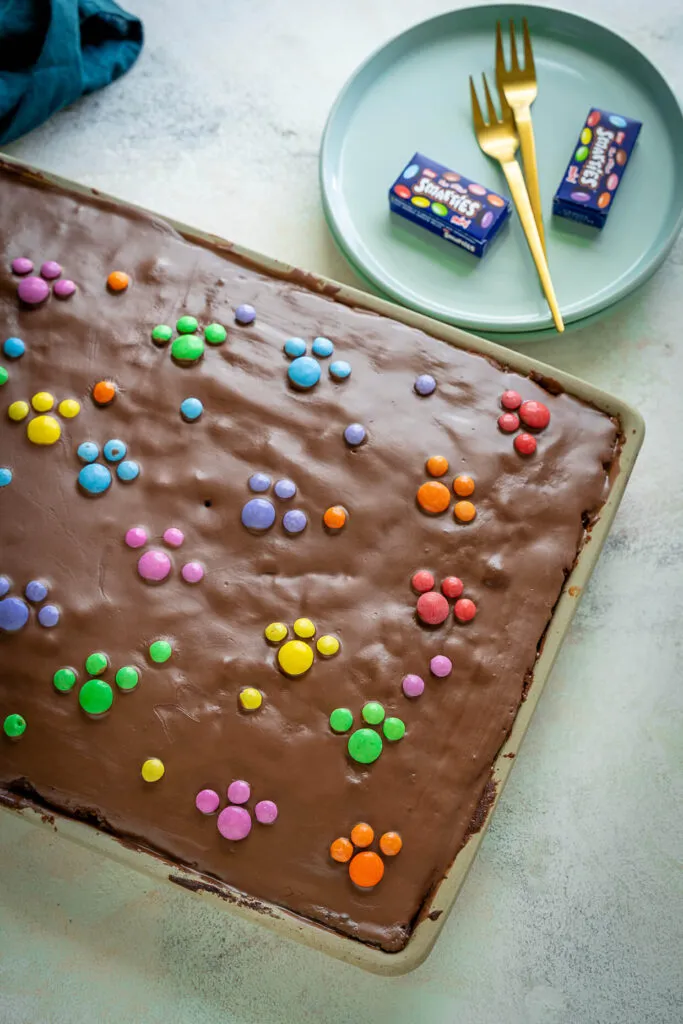 Frisch gebackener Blechkuchen mit Schokoladenglasur und bunten Streuseln, ein Highlight auf jeder Feier