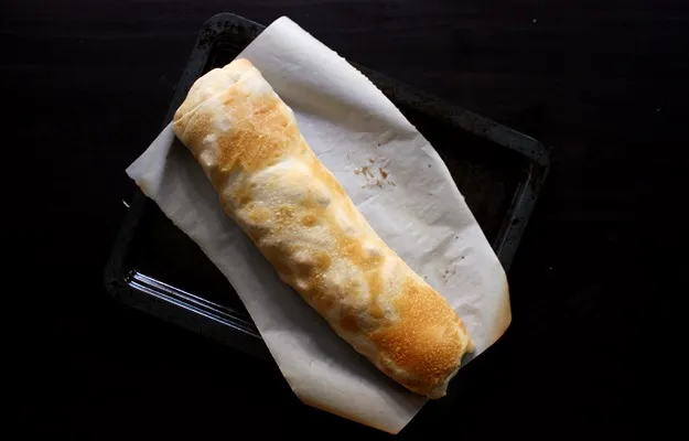 Frisch gebackener goldbrauner Apfelstrudel, direkt aus dem Ofen, das Ergebnis eines gelungenen Strudel Rezepts