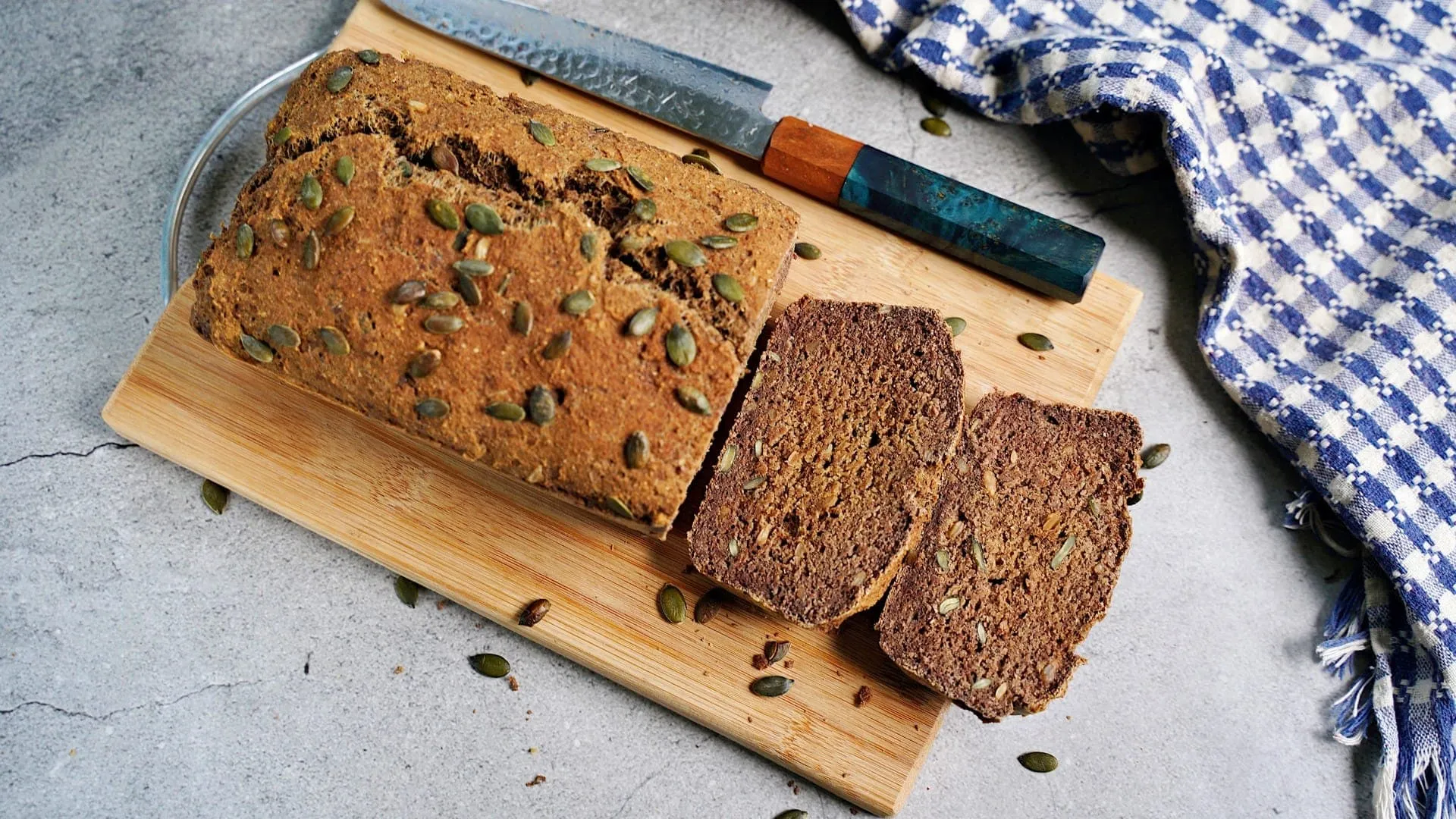 Frisch gebackener Linsenbrot-Laib mit goldbrauner Kruste und Kürbiskernen, ein veganes Eiweißbrot.