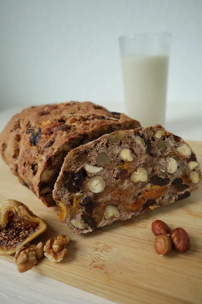 Frisch gebackenes Vollkorn Früchtebrot mit Nüssen und einem Glas Milch