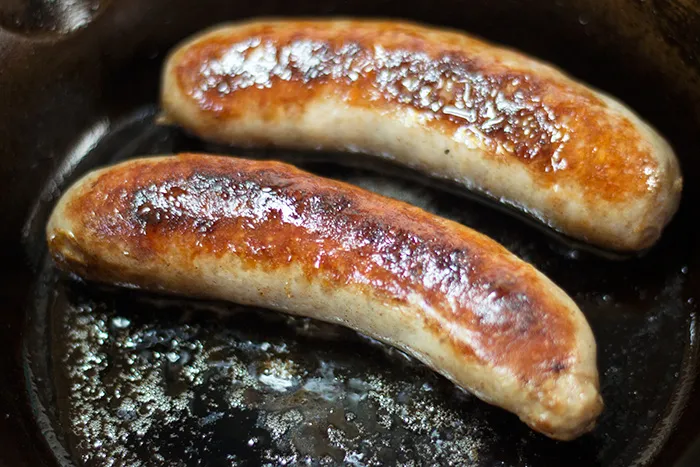 Frisch gebratene Bratwürste, in mundgerechte Stücke geschnitten, bereit für die Currywurst Soße