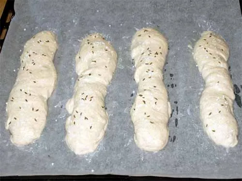 frisch geformte Schwäbische Seelen-Teiglinge bestreut mit Brezelsalz und Kümmel, bereit zum Backen