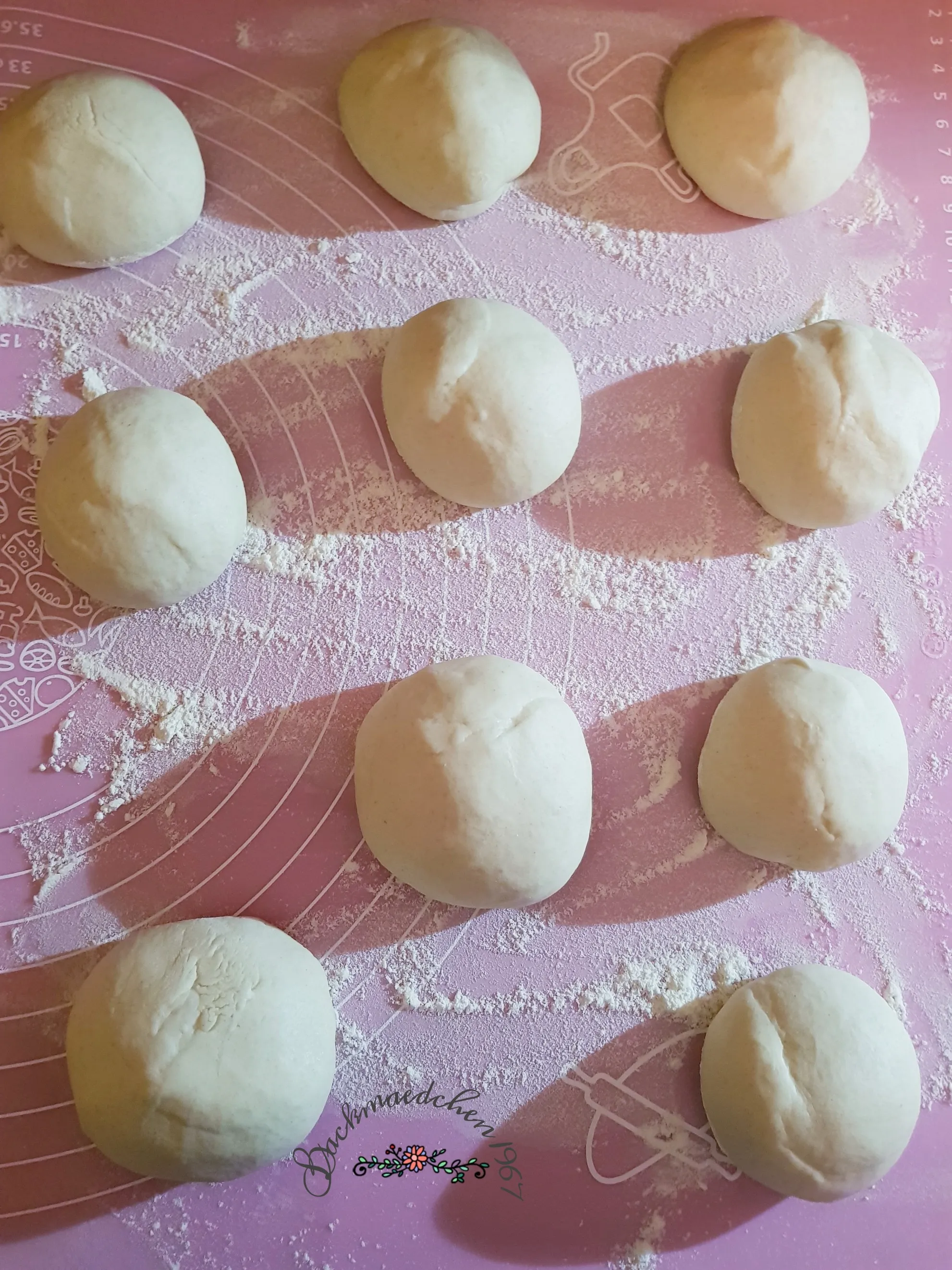 Frisch geformte Teiglinge für knusprige Sesambrötchen bereit zum Gehen