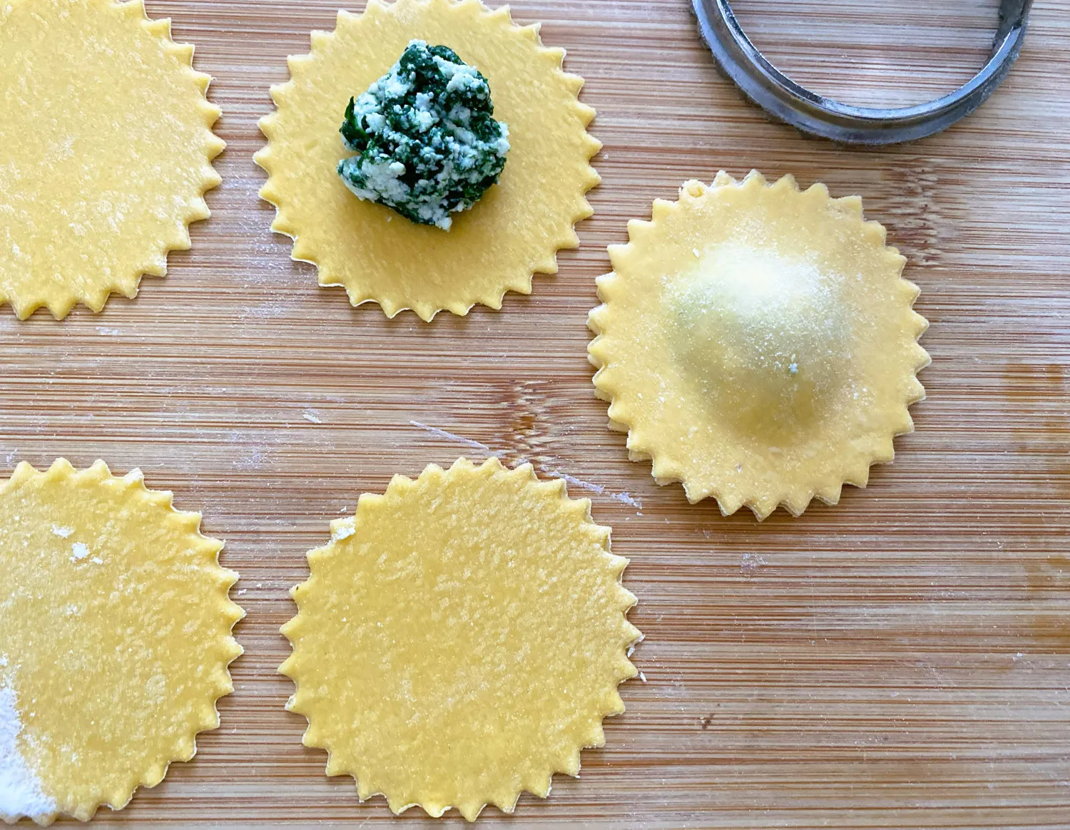 Frisch geformte, ungekochte Ravioli mit Spinat und Ricotta, bereit für das Kochwasser.