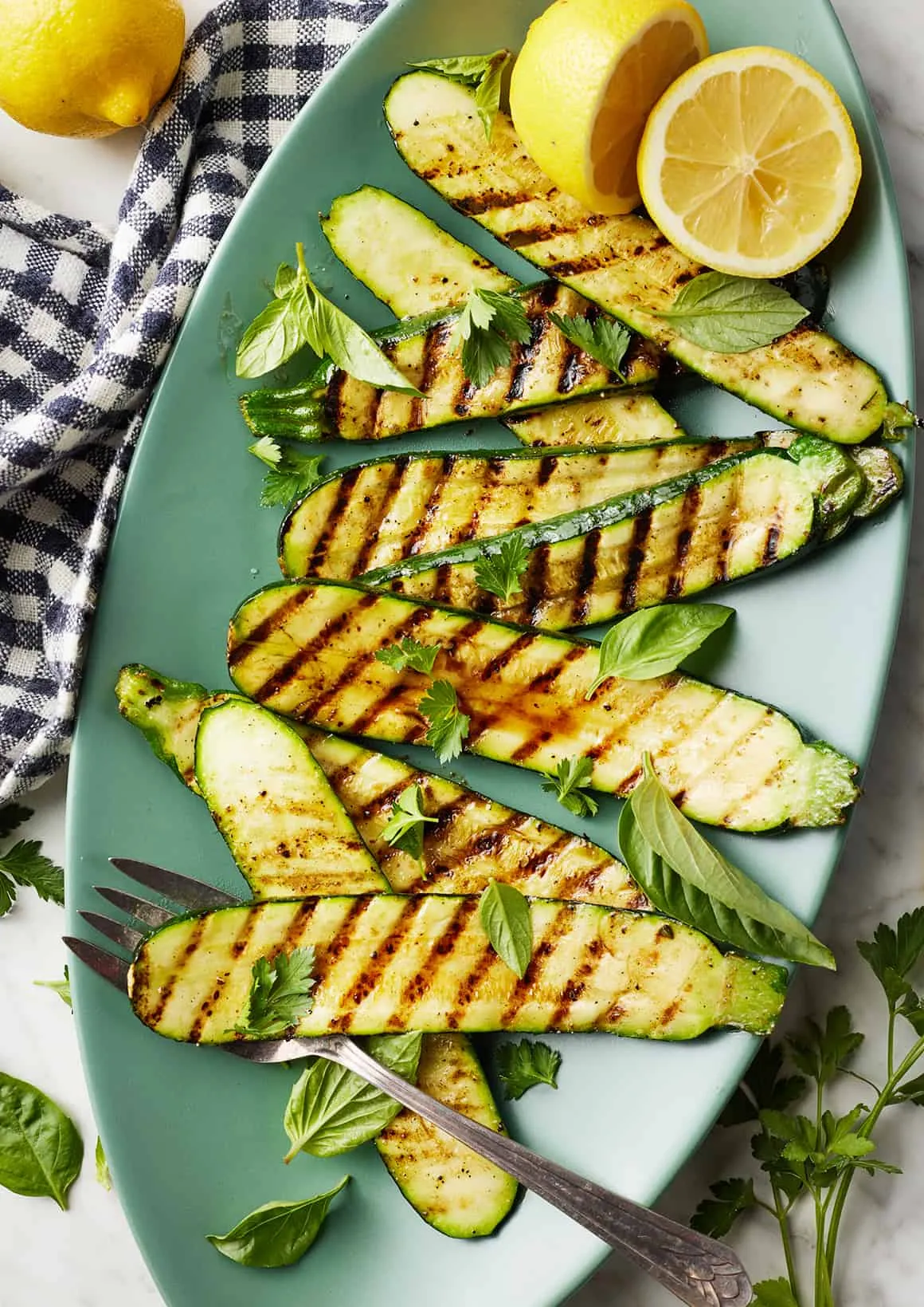 Frisch gegrillte Zucchini mit Zitronenspalten und Kräutern