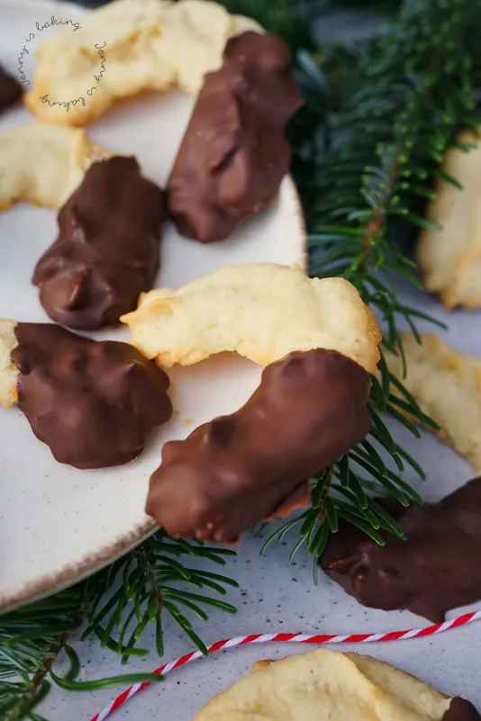 Frisch gespritzte Spritzgebäck-Plätzchen in Halbmondform auf Backpapier