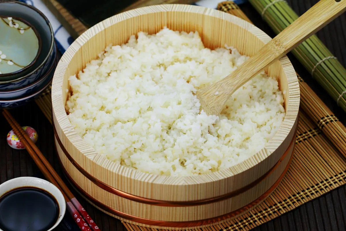 Frisch gewaschener, noch ungekochter Sushi Reis in einem Topf, bereit zum Kochen