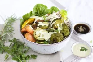 Frisch zubereitete Green Bowl mit veganem Caesar-Dressing, fertig zum Genießen oder als Meal Prep vorzubereiten