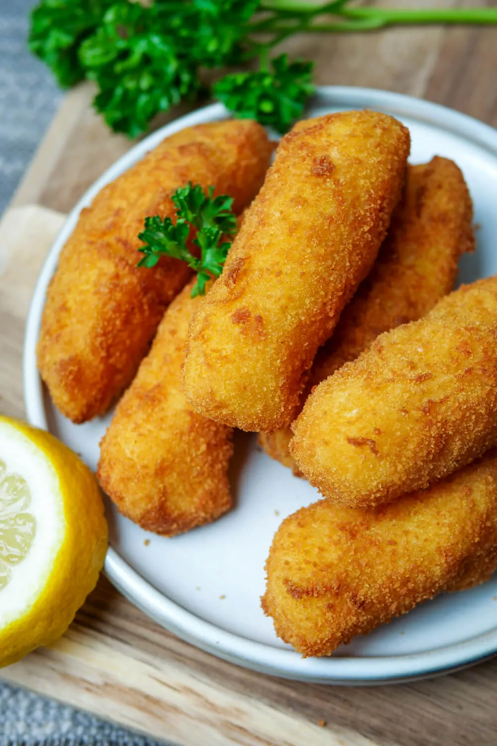 Frisch zubereitete Kroketten auf einem weißen Teller, garniert mit Petersilie