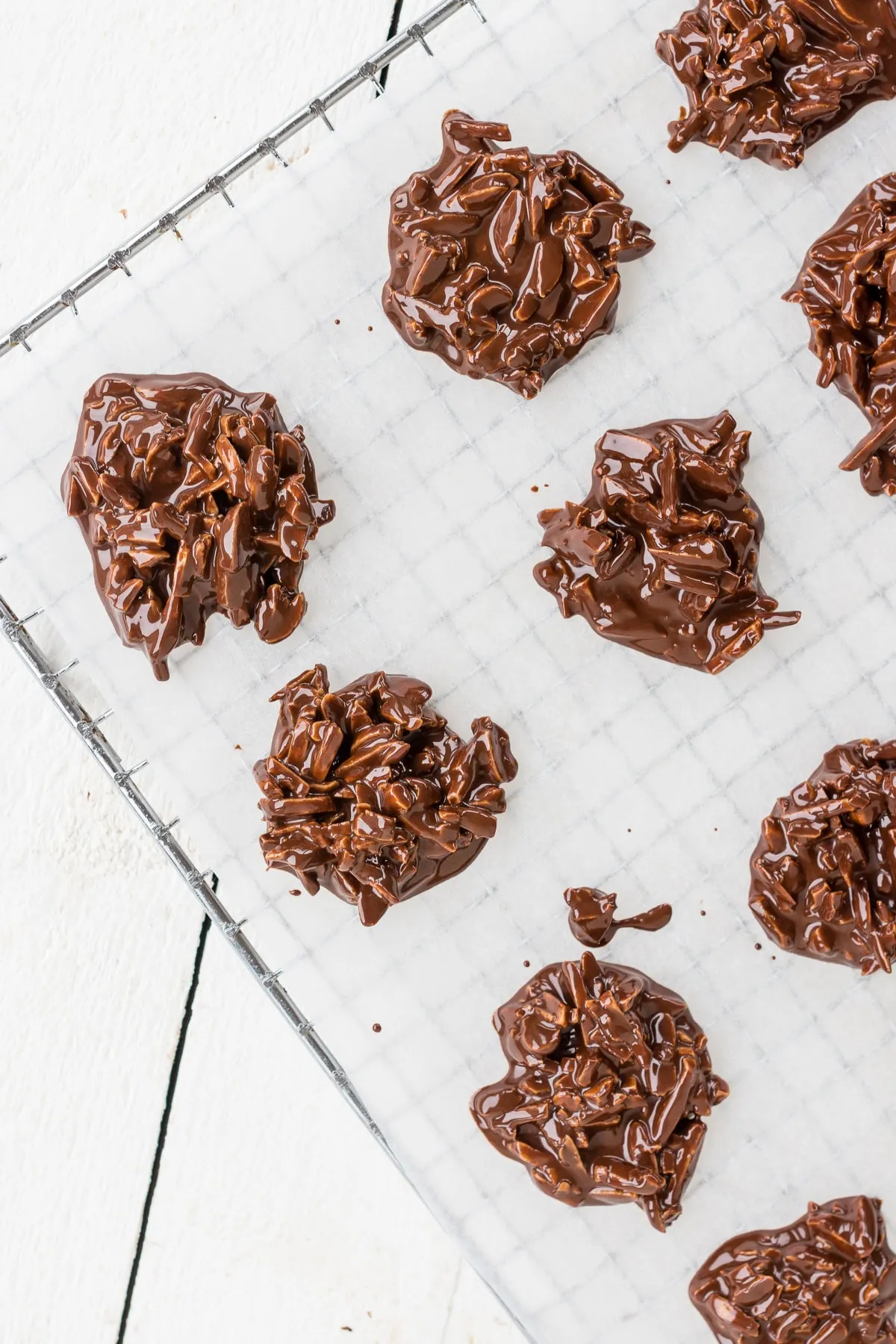 Frisch zubereitete Mandelsplitter in Schokolade auf Backpapier zum Abkühlen
