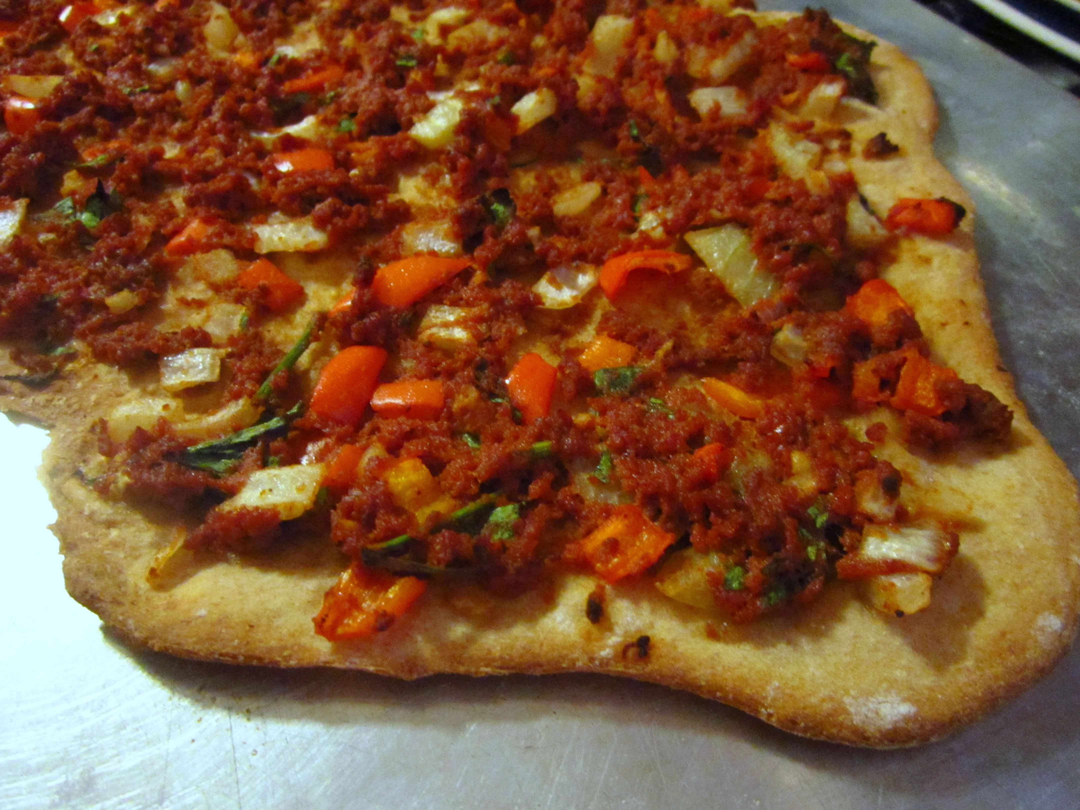 Frisch zubereitete türkische Pizza (Lahmacun) mit Salat, Zwiebeln und Zitrone, servierfertig in Deutschland.