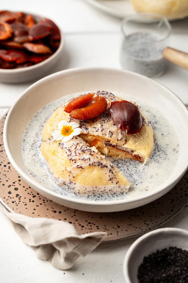 Frisch zubereiteter Germknödel, reichlich garniert mit gemahlenem Mohn und glänzender Soße, ein echter Genuss für Süßspeisen-Liebhaber.