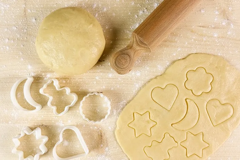Frisch zubereiteter Mürbteig für süße Kekse, ausgerollt und bereit zum Ausstechen.