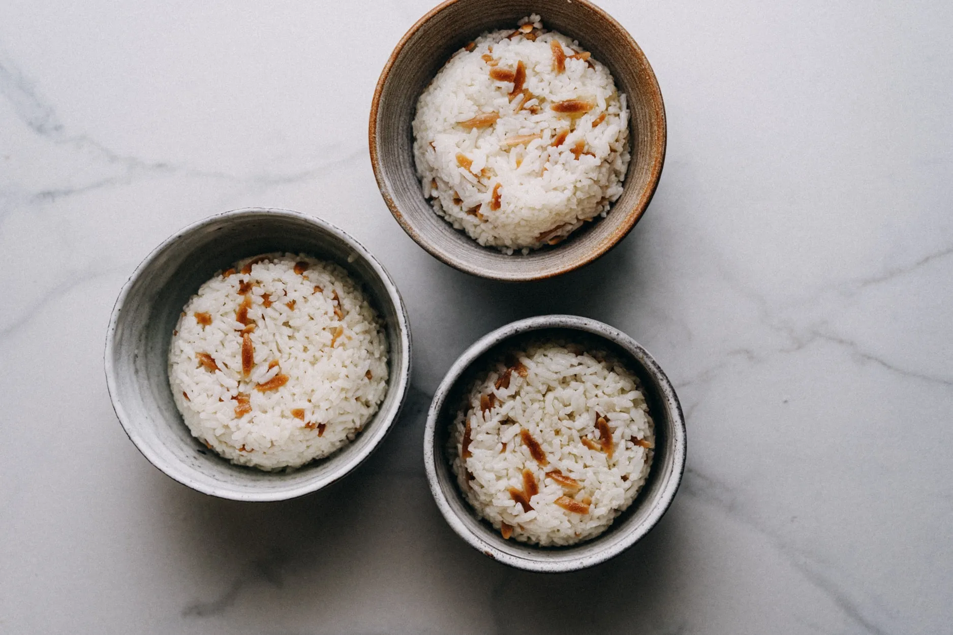 Frisch zubereiteter türkischer Reis, liebevoll in mehrere Schüsseln gefüllt, ideal als Beilage oder Hauptgericht.