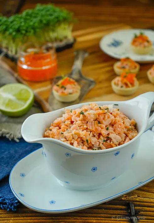 Frisch zubereitetes Räucherlachs Tatar auf Brötchenscheiben