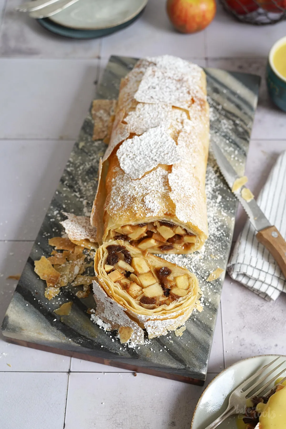 Frische Apfelwürfel mit Zitronensaft, braunem Zucker, Zimt und gehackten Keksen in einer Schüssel als Füllung für den Apfelstrudel.