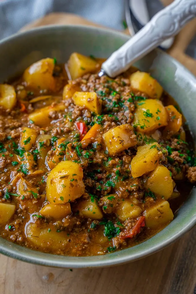 Frische Hauptzutaten für den Bauerntopf: Hackfleisch, Kartoffeln und bunte Paprika bereit zur Verarbeitung.