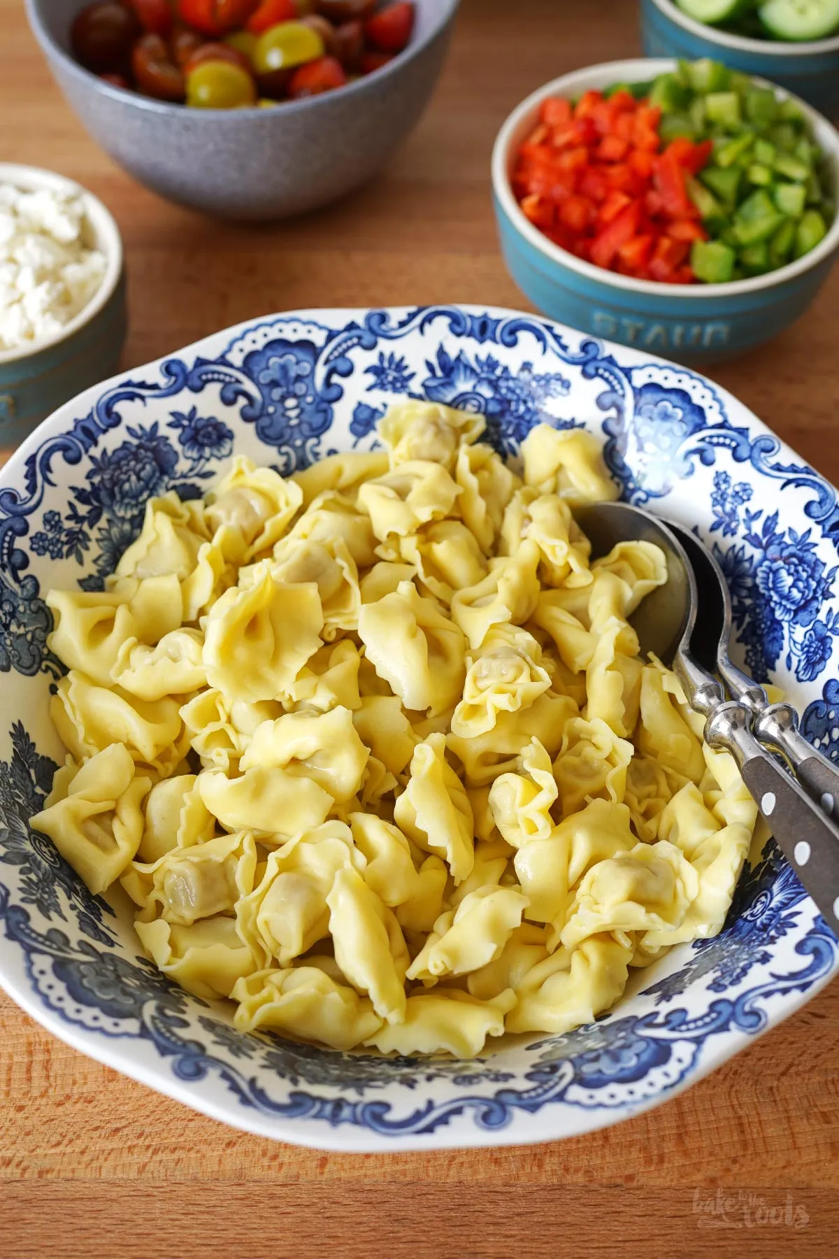 Frische Tortellini und bunte Gemüsezutaten wie Paprika und Kirschtomaten bereit für das Dressing