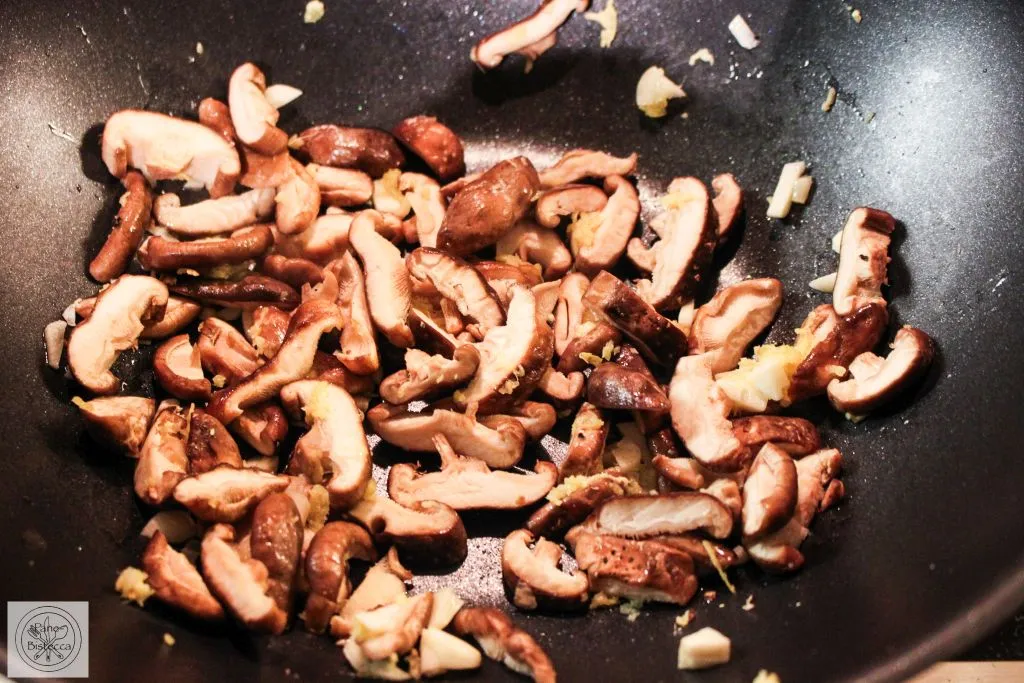 Frische Zutaten für asiatische Spinat Nudeln, darunter Shiitake Pilze und Frühlingszwiebeln