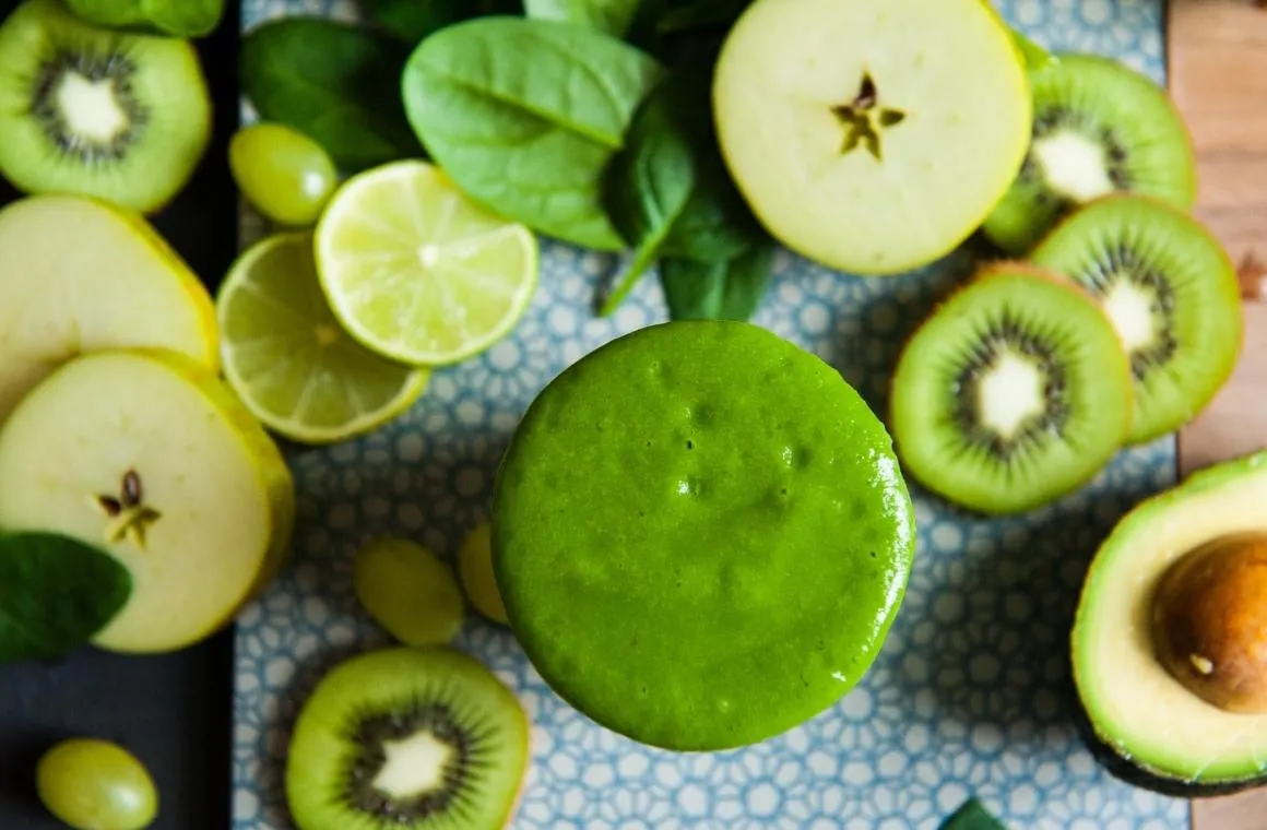 Frische Zutaten für den grünen Spinat Smoothie: Kiwi, Apfel, Avocado, Weintrauben und Limette