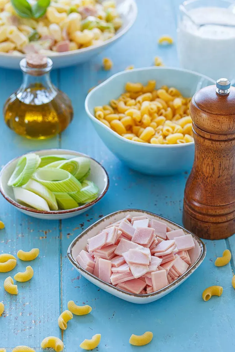 Frische Zutaten für eine selbstgemachte Sahnesoße: Lauch, Schinken, Sahne und Milch.