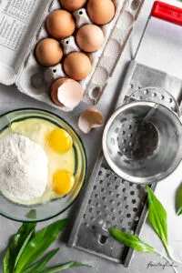 Frische Zutaten für Röstzwiebeln und Spätzle, darunter eine Zwiebel als Schlüsselzutat.