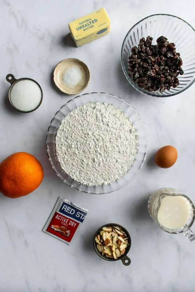 Frische Zutaten wie Mehl, Butter, Milch und Hefe für den Osterkranz, bereit zur Verarbeitung auf einer Marmoroberfläche.