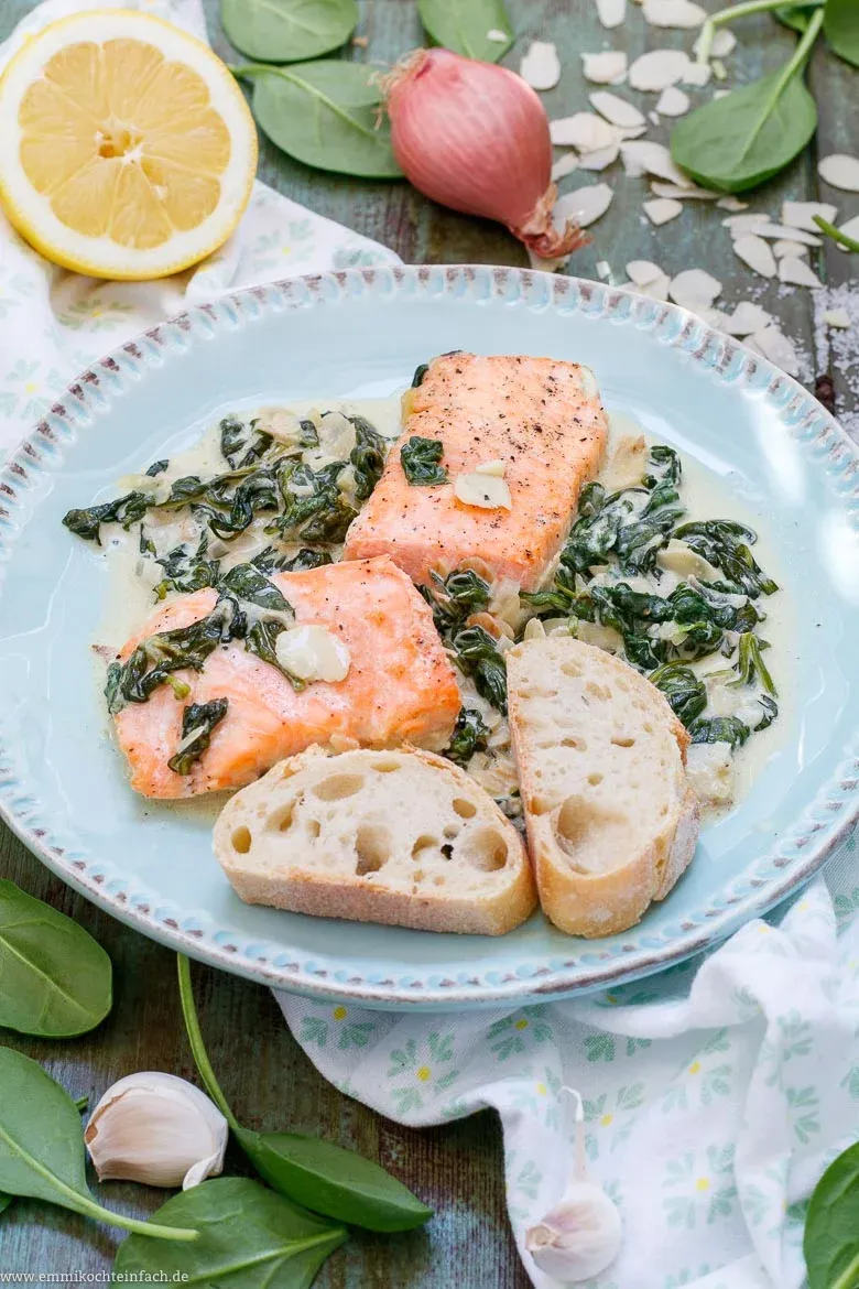 Frischer Blattspinat wird in einer großen Pfanne angedünstet, um die Basis für den Lachs Spinat Auflauf zu bilden.