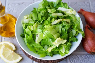 Frischer Endiviensalat mit Honig-Senf-Dressing und Zutaten für die Vinaigrette, appetitlich angerichtet für ein klassisches Endiviensalat Rezept.